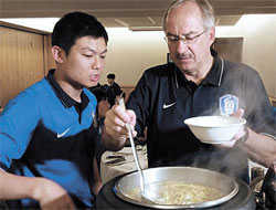新年初日、シュティーリケ監督が通訳のイ・ユンギュさん（左）と一緒に、選手のトック（雑煮）を準備している。（写真＝サッカー協会）