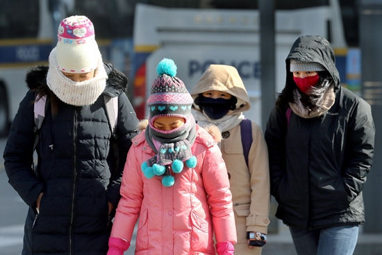 厳しい寒波が襲った８日、外国人観光客がソウル世宗大路を歩いている。