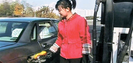 平壌市内のガソリンスタンドで女性給油員が車にガソリンを入れている。北朝鮮は優秀な人材を給油員に選抜し、燃料の着服を防いでいる。（中央フォト）