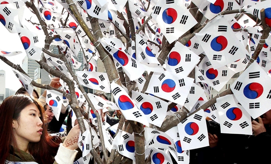２６日午後、ソウル光化門広場で市民が「太極旗の木」をつくっている。