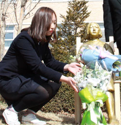 平和の少女像を描いたキム・ミンジさんが少女像のそばに花束を置いている。（写真＝木川高）