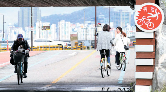 ２０日、漢江（ハンガン）市民公園の汝矣島（ヨイド）地区で市民がヘルメットをかぶらず自転車に乗っている。自転車道路には危険性を知らせる表示板があるが無意味だった。安全な自転車運転のためにはヘルメットを必ず着用すべきだ。