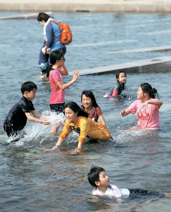 初夏の陽気となった２６日、ソウル汝矣島（ヨイド）水色広場で子供たちが水遊びを楽しんでいる。