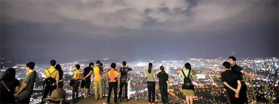 大邱アプサン展望台から夜景を眺めている観光客。展望台にはケーブルカーを利用する。（写真＝韓国観光公社）