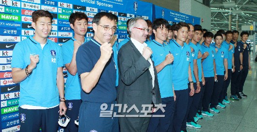 ８日、仁川国際空港でポーズを取っている韓国サッカー代表チームのメンバーおよびスタッフ。