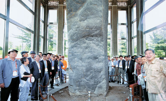 先月２４日、中国吉林省集安市太王村に立っている「広開土大王碑」で記念撮影をしている「平和オデッセイ２０１５」の参加者。