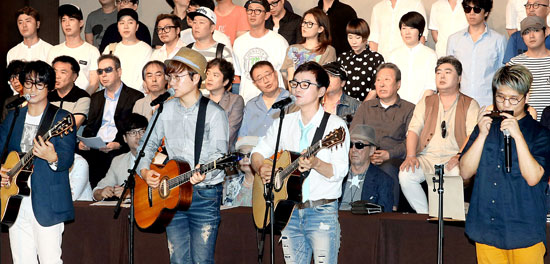 ２０日、ソウル汝矣島６３ビルのコンベンションセンターで放送音楽使用料分配規定を批判する記者会見が開かれた。写真最前列左側からユリサンジャのパク・スンファ、イ・セジュン、チュ・ガヨルらがヘバラギの『サランヘ』を一緒に歌っている。