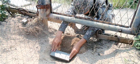 ４日、非武装地帯で北朝鮮軍が埋めた木箱入り地雷が爆発し、下士官２人が負傷した現場。軍合同調査団が埋設状況を再現している。（写真＝合同参謀本部）