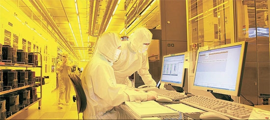 京畿道華城市のサムスン電子半導体ラインでエンジニアたちがコンピュータを通じて工場の状態を点検している。生産工程は先端装備を通じてオートメーション化されている。（写真＝サムスン電子）