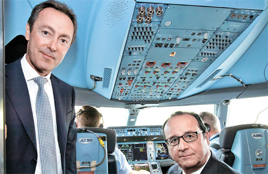今年６月パリのエアショーで、エアバスのファブリス・ブレジエ会長とオランド仏大統領がエアバスの最新の親環境・高効率航空機Ａ３５０の操縦席を見回している。（写真＝エアバス）