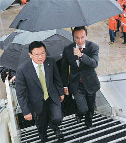 ブレジエ会長が傘を持って朴三求（パク・サムグ）錦湖（クムホ）アシアナ会長をＡ３８０航空機の入口に案内している。（写真＝エアバス）
