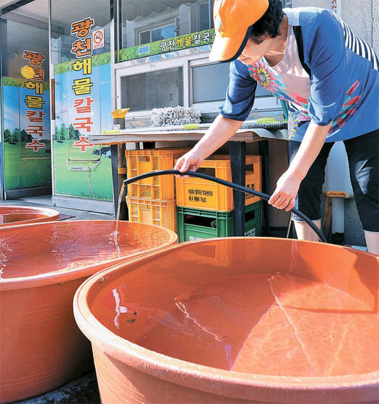 ８日、洪城（ホンソン）のある飲食店の主人が大きなたらいに水をためてもらっている。