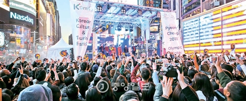２３日（現地時間）、ニューヨークのタイムズスクエアで開かれた韓国文化観光大展イベントで韓国のアイドルグループ「ＴＥＥＮ　ＴＯＰ」が大勢の人々に取り囲まれたまま公演をしている。