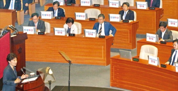 朴槿恵（パク・クネ）大統領が２７日、国会で来年度予算案の施政演説を行っている間、新政治民主連合の議員らがコンピューターモニターの裏面に「国定教科書反対」などと書かれた紙を張り付けて座っている。