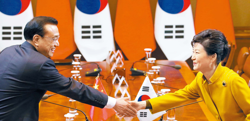 朴槿恵大統領（右）と中国の李克強首相が３１日午後、青瓦台で韓中首脳会談に先立ち握手を交わした。双方は韓中ＦＴＡの年内発効を積極的に推進することにした。（写真＝青瓦台写真記者団）