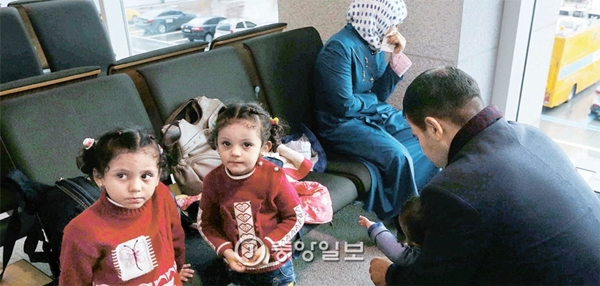 シリア難民だと明らかにした家族が１８日、仁川（インチョン）空港の入国場に座っている。国家情報院はこの日、国会情報委で「シリア難民２００人が難民申請をした」と明らかにした。