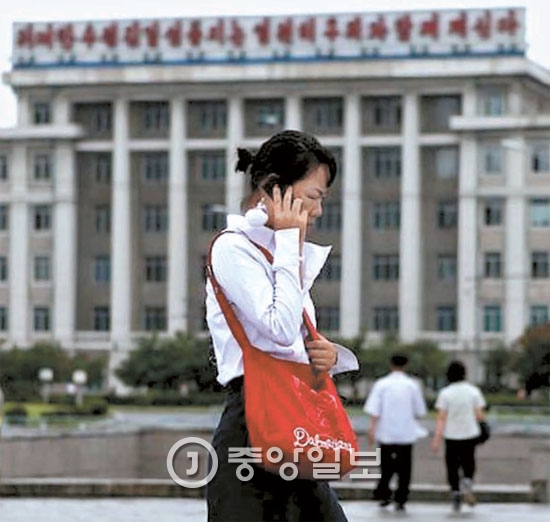北朝鮮女性が携帯電話で通話しながら歩いている。北朝鮮は２００２年から携帯電話を普及させた。（中央フォト）