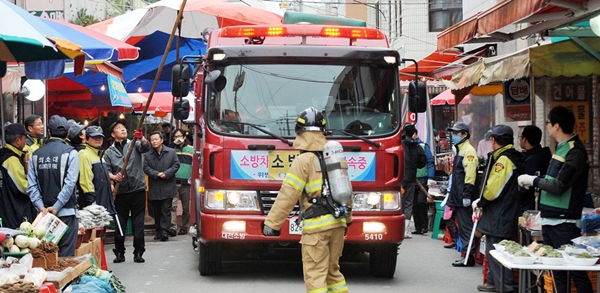 ２４日、大田市の儒城市場で開かれた冬季の火災に備えた消防通路確保訓練が実施され、消防車が狭い市場の通路を注意深く通り抜けている。