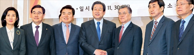 金武星（キム・ムソン）セヌリ党代表と文在寅（ムン・ジェイン）新政治民主連合代表が３０日、国会で韓中自由貿易協定（ＦＴＡ）批准同意案の処理に合意した後、握手している。