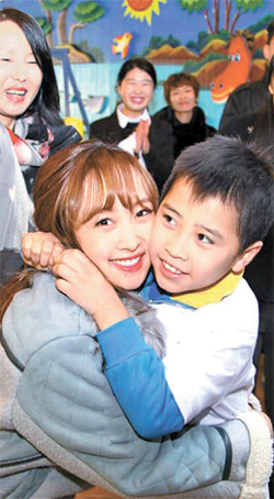 中国遼寧省瀋陽市の障がい者リハビリセンターを訪れて子供と抱擁している韓流スターのニコル（左）。ニコルはＫＯＴＲＡの広報大使として中小企業の韓流マーケティングを支援するために瀋陽を訪問した。（写真提供＝ＫＯＴＲＡ）
