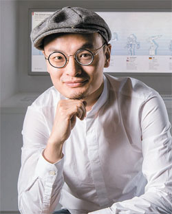 中国ドローン製造企業ＤＪＩの創業者の汪滔氏が本社１４階のドローン展示館の前に座っている。（写真＝ＤＪＩ）