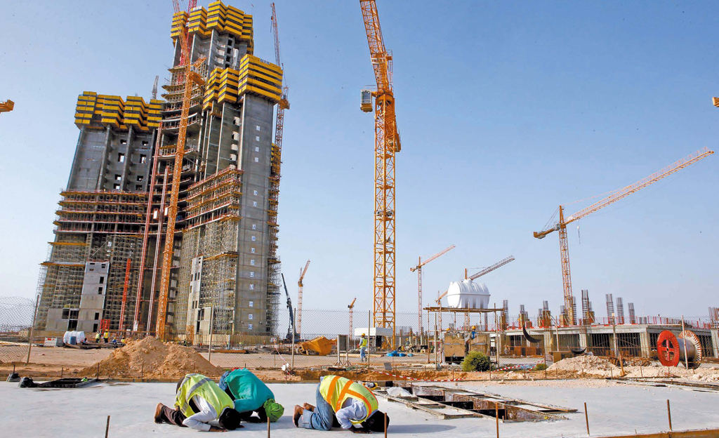 １９日現在で３１階まででき上がったサウジアラビアのチェダ市のキングダムタワー建設現場で、労働者たちがイスラム聖地メッカに向かって礼拝をしている。この建物は２０１８年１２月に地下１５０メートル、地上２００階１００８メートルの世界最高層の建物として完工する予定だ。現在の世界最高層の建物はアラブ首長国連邦のドバイのブルジュ・ハリファで１６０階建て８２８メートルだ。