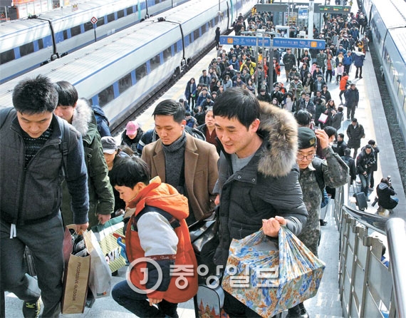 ９日、故郷からの帰京客が贈り物の包みを両手いっぱいに持ってソウル駅プラットフォームに降り立っている。