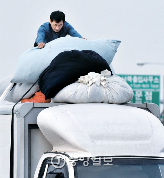 開城工団から完成品を運んできたある労働者が１１日、自由路で荷物を移動させている。
