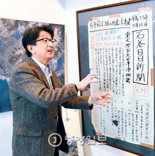 東日本大震災時、石巻日日新聞の報道デスクだった武内宏之常務が４日、新聞社の博物館に展示された手書きの壁新聞について説明している。