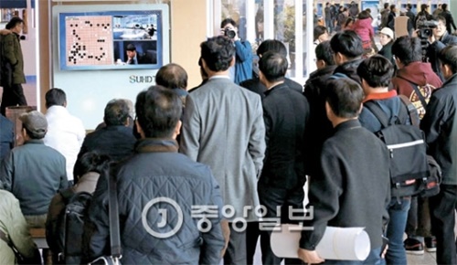 ソウル駅を利用する乗客が１０日午後、待合室で李世ドル（イ・セドル）九段とグーグルの人工知能（ＡＩ）「アルファ碁」の第２局の対決をテレビで見守っている。