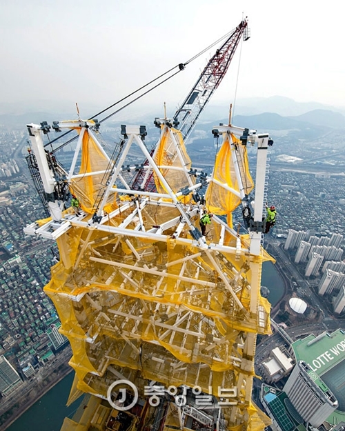 １７日、ソウル蚕室のロッテワールドタワーの最上層部に尖塔構造物が設置された。