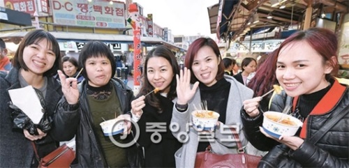 ２７日、仁川モレネ市場でトッポッキを買って食べている中国アオラングループ所属の観光客。