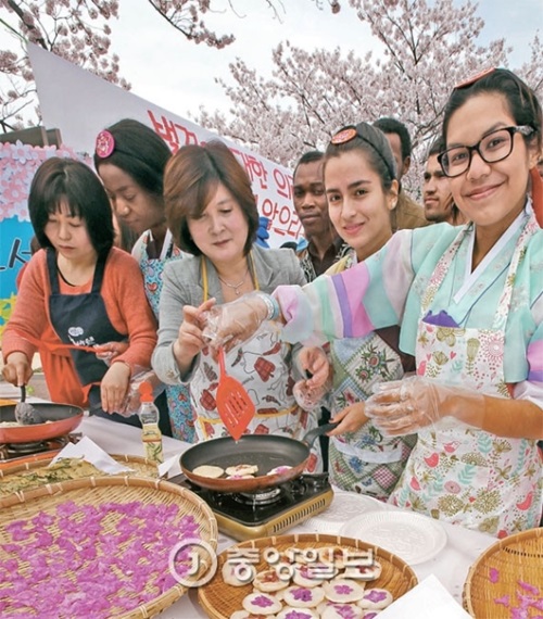 ５日、桜の花が満開の新羅大国際教育館の前で外国留学生が花煎を作っている。