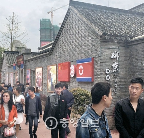 従業員１３人が集団脱出した中国浙江省寧波の「柳京朝鮮食堂」の前を１０日、中国人が歩いている。食堂の壁には北朝鮮の国旗と中国の五星紅旗が設置されている。この食堂は従業員が韓国に到着した７日に閉店した。
