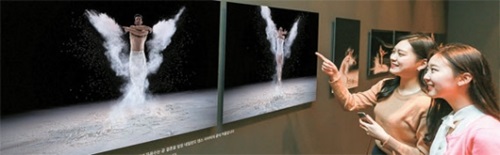 サムスン電子がソウル新寺洞カロスギルで２１日まで運営している「ギャラクシーＳ７芸術写真プロジェクト」ポップアップギャラリーで写真を見ている観覧客。（写真＝サムスン電子）