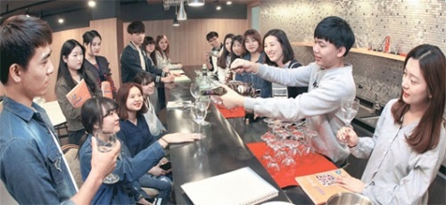 永進専門大観光通訳班留学生が１８日、ワインをサービスするという状況を仮定して韓国語を学んでいる。