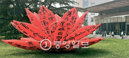 ２９日、中国北京の釣魚台国賓館の芝生に展示された「８０８呼吸する花」。韓日中３０人会議が制定した共用漢字８０８字をモチーフにしたレンゲ型の作品。
