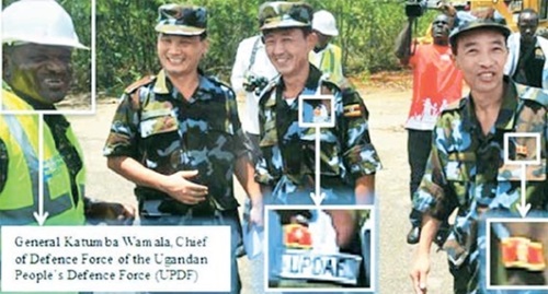 ２０１４年４月、ウガンダのナカソンゴラ空軍基地で活動中の北朝鮮教官３人とカトゥムバ・ワマラ・ウガンダ防衛軍司令官（左）。国連安保理対北制裁委専門家パネルの報告書（２０１６年）は「北朝鮮の教官がウガンダ空軍服を着て、胸には指導者（金日成と推定）の顔が入ったバッジを付けている」と明らかにした。（写真＝国連専門家パネル報告書）