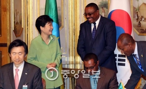朴槿恵大統領とエチオピアのハイレマリアム・デサレン首相が２６日午後（現地時間）、アディスアベバ大統領宮で首脳会談を終えた後に談笑している。尹炳世（ユン・ビョンセ）外交部長官（前列左）とテフェラエチオピア農林資源部長官が両首脳の前でセマウル運動協力など両国ＭＯＵに署名している。