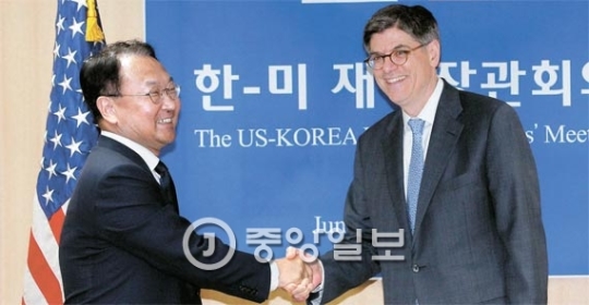韓米財務相会談が３日、政府ソウル庁舎で行われた。柳一鎬（ユ・イルホ）経済副首相兼企画財政部長官（左側）とルー米国財務長官が握手している。