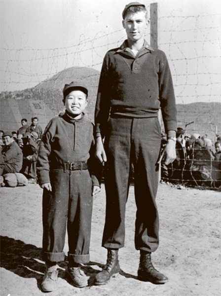 ２０日から始まる韓国国家記録院の展示会「護国報勲の精神、記録で振り返る」で公開されている写真。１９５１年のもので、１２歳の北朝鮮軍捕虜と国連軍が並んで立っている。（写真＝国家記録院）