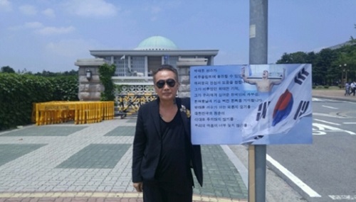 写真作家のキム・ジュンマンさんが競泳選手の朴泰桓のリオ五輪出場を許さない大韓体育会の決定に反対してソウル汝矣島国会前で一人デモをしている。（写真＝キム・ジュンマン・スタジオ）