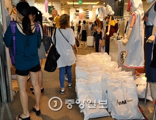 １５日深夜、ソウル・東大門の卸売商街で顧客が商品を見ている。彼らの大部分は中国のバイヤーだ。床にあらかじめ注文したサンプルが積まれている。