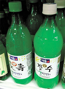 長寿マッコリはボトルのキャップで使用米を区分できるようにしている。国産米を使っている場合は白色（右）、輸入米の場合は緑色だ。