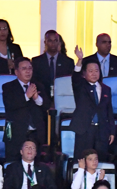 北朝鮮の崔竜海（チェ・ヨンヘ）国務委員会副委員長（右）が、２０１６リオ五輪開会式で入場行進する北朝鮮選手団に手を振っている。（写真＝オリンピック写真共同取材団）