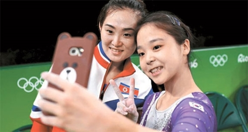 ８日に開かれたリオデジャネイロオリンピック女子体操の予選で一緒に写真を撮っている北朝鮮のホン・ウンジョン（左）と韓国のイ・ウンジュ。