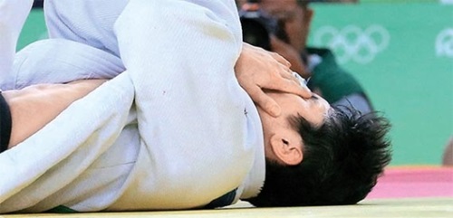 柔道男子６０キロ級の３回戦で指導を取られて畳の上で顔を覆うキム・ウォンジン。（リオデジャネイロ＝オリンピック写真共同取材団）