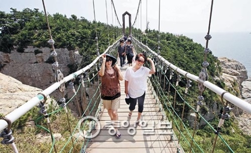 今月１６日、慶尚南道統営市（キョンサンナムド・トンヨンシ）の欲知島（ヨクチド）にある吊り橋（長さ３０メートル、幅１．５メートル、高さ４０メートル）。釜山（プサン）から来たペク・ソンエさん（５４）と大学の友人４人が橋を渡りながら楽しんでいる。彼らは「若い頃を忘れないでおこうと集まりの名前を『アカシア』と決めたが、ここに来るとその頃のロマンがよみがえる」と話していた。