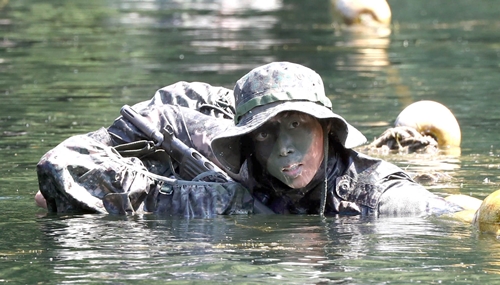 女性軍初のレンジャー過程に挑戦したイ・セラ中佐が２４日、忠清南道和順の陸軍歩兵学校遊撃訓練場で水中浸透訓練を行っている。