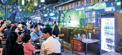 ベトナムの首都ハノイ中心街チュックバック通りに期間限定でオープンしたポップアップストア「真露ハイト焼酎クラブ」。現地のベトナム人が集まり韓国焼酎を楽しんでいる。１１月まで３カ月間営業するポップアップストアでは焼酎カクテルショーとベトナムの人気歌手公演など多彩なイベントが行われる。（写真＝ハイト真露）
